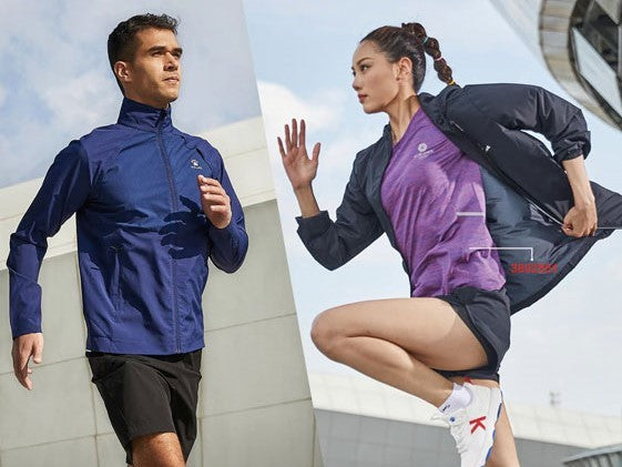 A man and a woman pictured mid run. Wearing KELME training gear. KELME Training Jacket. KELME Training T-Shirt. KELME Training Shorts.